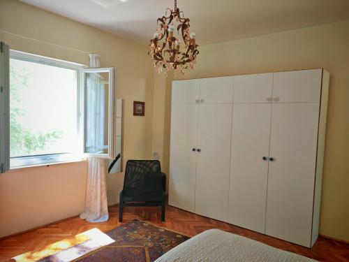 a bedroom with a large white cabinet and a chandelier at Petra's House in Komaji