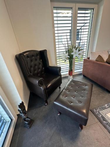 a leather chair and an ottoman in a living room at V.I.P Appartement in Böttstein