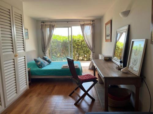 une chambre avec un lit, un bureau et une fenêtre dans l'établissement Bonifacio accès mer et golf - vue exceptionnelle, à Bonifacio