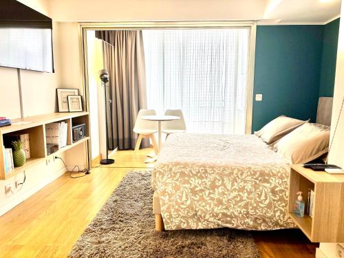 une chambre avec un lit et une grande fenêtre dans l'établissement Studio Cosy Pradignac, à Cannes
