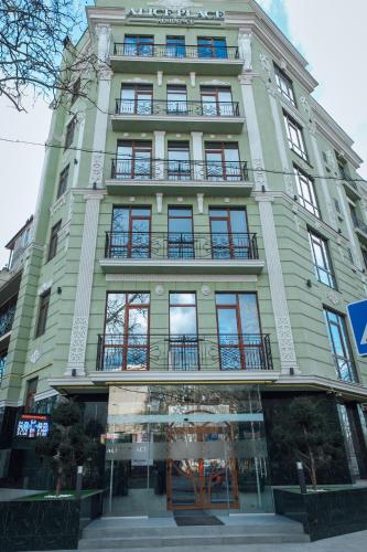 オデッサにあるAlice Place Hotelの窓とバルコニー付きの高い緑の建物