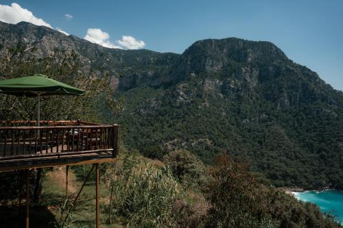 a balcony with an umbrella on top of a mountain at Olive Garden Kabak in Faralya
