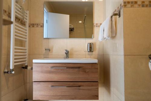 a bathroom with a sink and a mirror at Hotel Cristal in Mamaia Sat/Năvodari