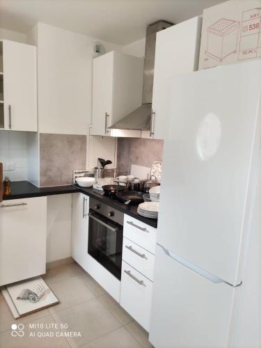 une cuisine avec des armoires blanches et une cuisinière dans l'établissement Appartement proche des puces de Saint-Ouen, à Saint-Ouen