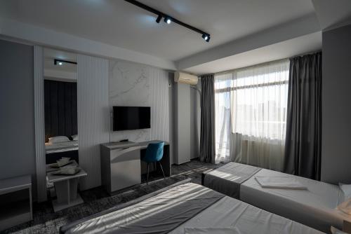 a bedroom with a bed and a desk and a television at Hotel Cristal in Mamaia Sat/Năvodari
