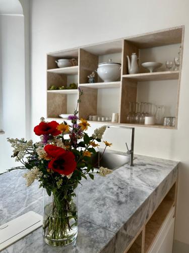 a vase with flowers on a counter in a kitchen at Palazzo Palloni: Piano Nobile in Sorano