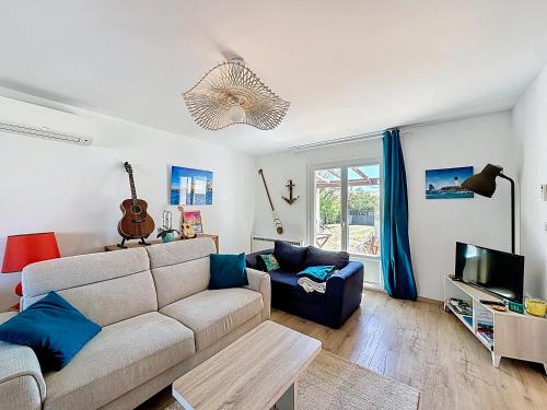 un salon avec un canapé et une télévision dans l'établissement Maison avec jardin sur marseillan, à Marseillan