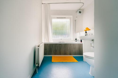 a bathroom with a toilet and a window at 2 Bedroom Apartment Near London Bridge with a Garden in London