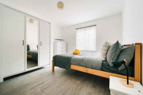 a bedroom with a bed and a mirror at 2 Bedroom Apartment Near London Bridge with a Garden in London