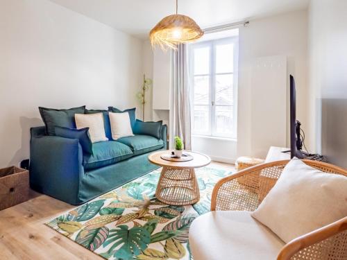 un salon avec un canapé bleu et une table dans l'établissement OIQIA • Advena • Floralis, à Annonay