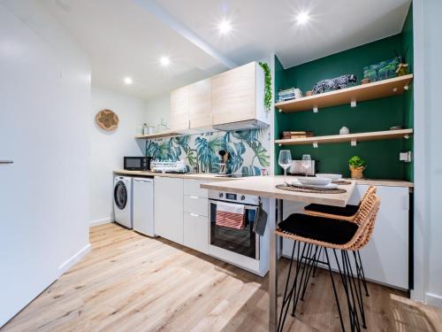 une cuisine avec des murs verts et une table et des chaises dans l'établissement OIQIA • Advena • Floralis, à Annonay