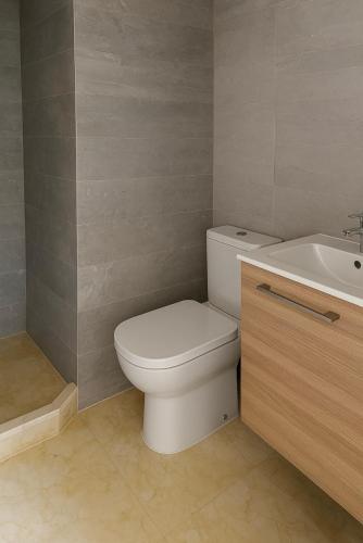 a bathroom with a white toilet and a sink at Sublime T3 bord de mer avec piscine & Balcon I Proche Aéroport in Hajreien
