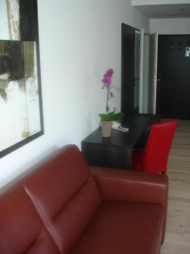 a living room with a red couch and a black table at Seehotel Lilly in Strobl