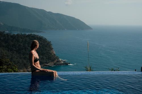 a woman sitting on an object in the water at Olive Garden Kabak in Faralya