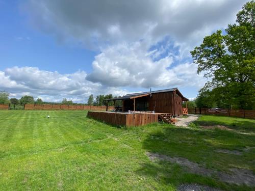 a smallshed in a field with a green field at Drewniana ostoja in Jelonek