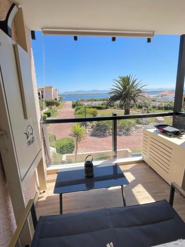un balcon avec une table et une vue sur l'océan dans l'établissement Cap Coudalère entre lac et mer, au Barcarès