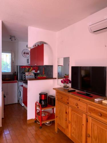 une cuisine avec une télévision à écran plat sur une commode en bois dans l'établissement Résidence Plein Sud, à Argelès-sur-Mer