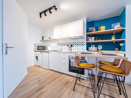 - une cuisine avec des placards blancs et des murs bleus dans l'établissement OIQIA • Advena • Montgolfier, à Annonay