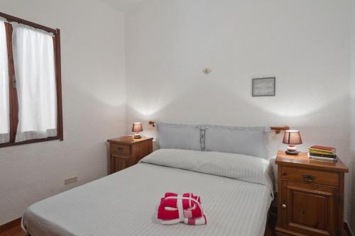 a bedroom with a bed with a red backpack on it at Villetta con terrazza a 400 mt dal mare in Geremèas