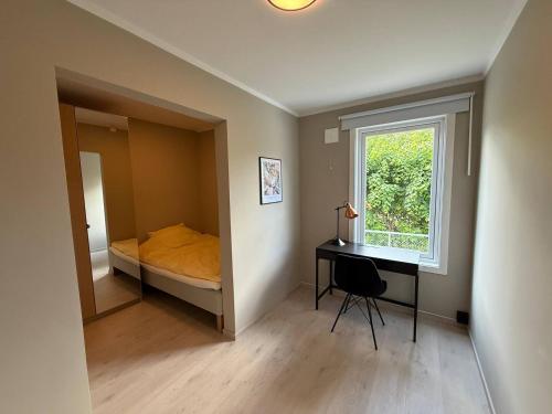 a bedroom with a bed and a desk and a window at Moderne hus i sentrum av Lillestrøm in Lillestrøm