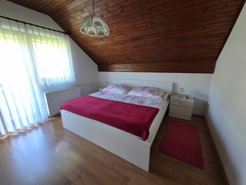 a bedroom with a bed with a red blanket at Apartma Maržič in Kranjska Gora