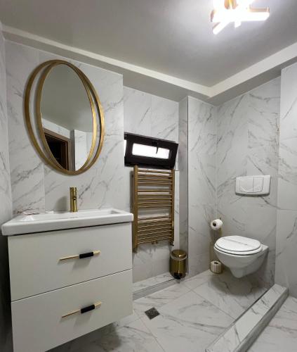 a bathroom with a sink and a toilet and a mirror at Eden Boutique in Bucharest