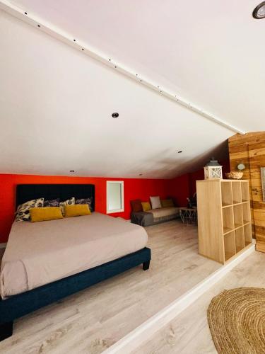 une chambre avec un lit et un mur rouge dans l'établissement Charmant appartement 6 couchages, à Sommières