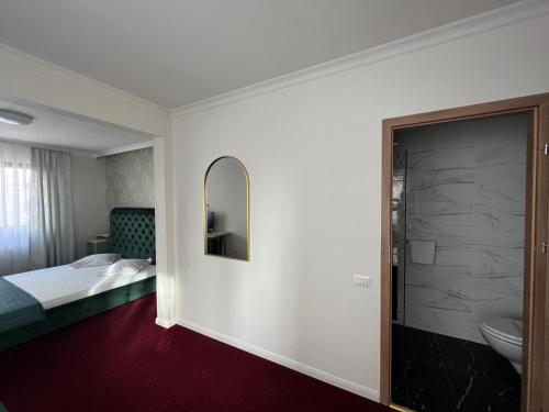 a hotel room with a bed and a mirror at Eden Boutique in Bucharest