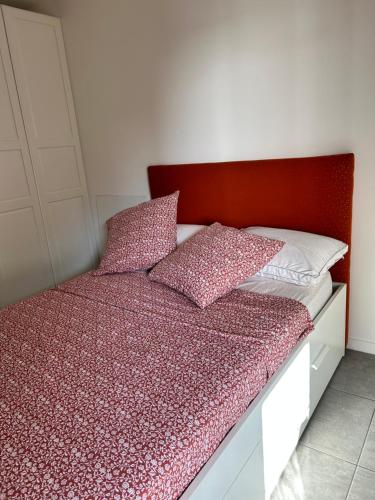 - un lit avec une tête de lit rouge et des oreillers dans l'établissement Porticcio Agosta, à Albitreccia