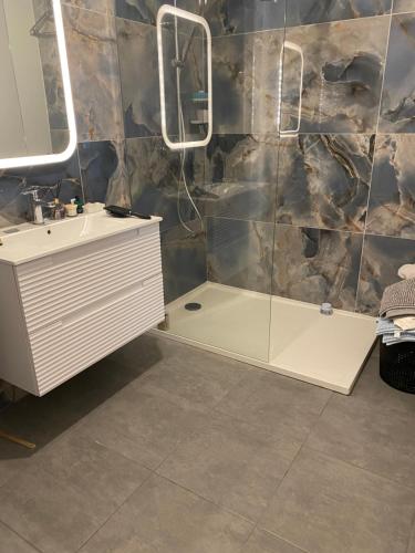 une salle de bain avec un lavabo et une douche dans l'établissement Porticcio Agosta, à Albitreccia