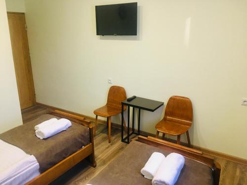 a room with two beds and a table and two chairs at Guesthouse Chambarak in Chambarak