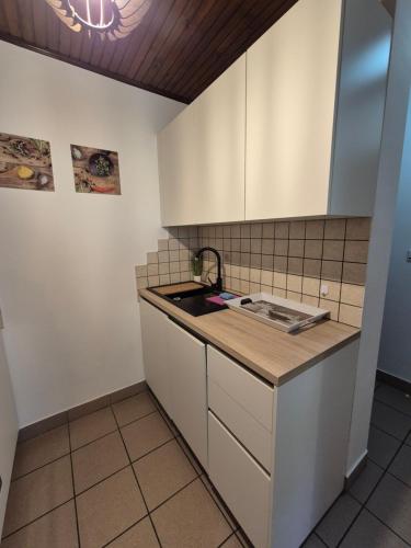 a kitchen with white cabinets and a sink at Apartma Maržič in Kranjska Gora