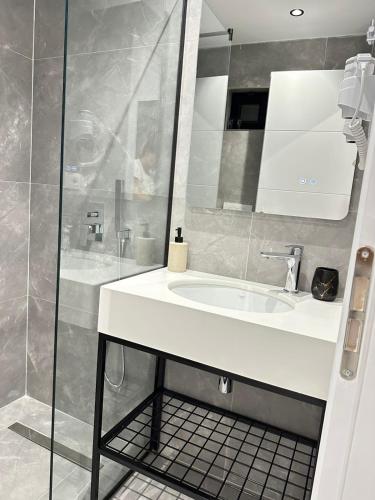 a bathroom with a white sink and a shower at Wait 'n Sea in Himare