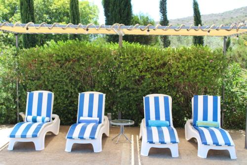 three blue and white striped chairs and a table at St.George's Country Retreat in Limassol