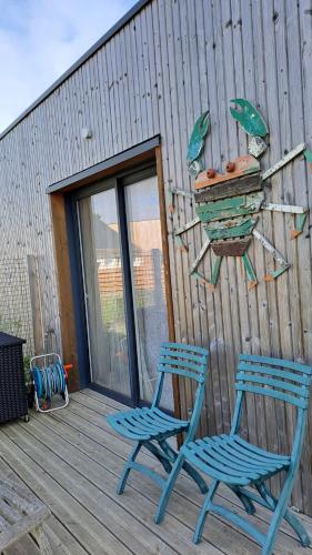 deux chaises bleues et une jardinière sur une terrasse dans l'établissement Park Mézévéno, à Trévou-Tréguignec