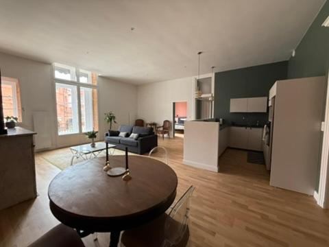 un grand salon avec une table et un canapé dans l'établissement La réserve des drapiers, à Montauban