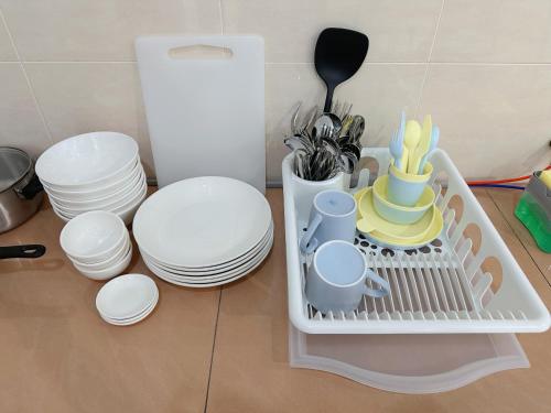 a dish drying rack with dishes and plates and utensils at 10Pax BM大山脚 Alma Single storey Semi-D 5-minute To Aeon Mall in Bukit Mertajam