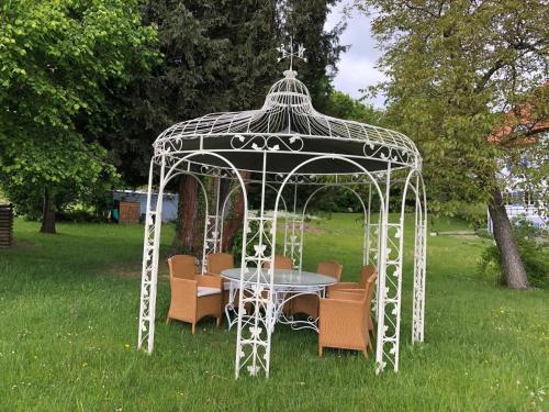 a gazebo with a table and chairs in the grass at Ferienwohnung Villa Victoria mit grandiosem Seeblick und Gartennutzung in Jugendstil Villa in Gstadt am Chiemsee