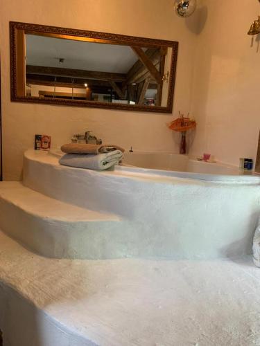 a bath tub with a sink and a mirror at Ferienhaus Feuer Wasser Luft Erde in Dobbrikow