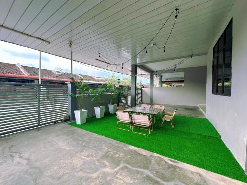 a patio with a table and chairs and grass at 10Pax BM大山脚 Alma Single storey Semi-D 5-minute To Aeon Mall in Bukit Mertajam