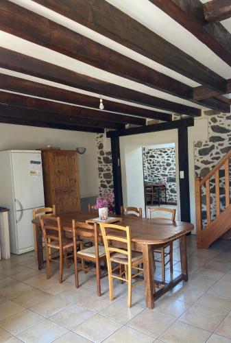 une salle à manger avec une table et des chaises en bois dans l'établissement Maison chaleureuse toute équipée pour vos vacances, à Saint-Quay-Portrieux