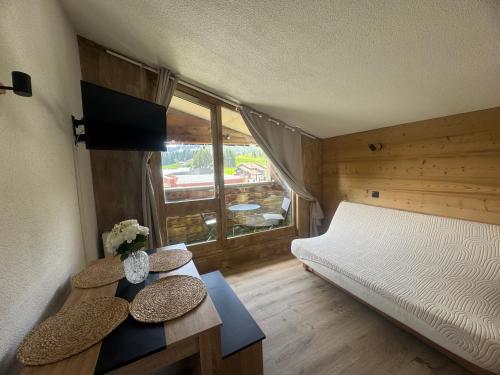 une petite pièce avec un lit et une fenêtre dans l'établissement Appartement au pied des pistes, à Taninges