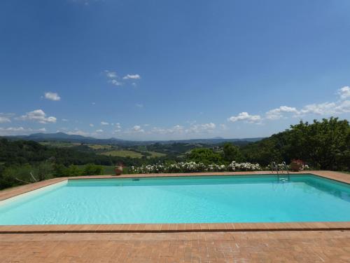 a swimming pool with a view of the mountains at SCAPPO IN UMBRIA, il Fienile in Fornole