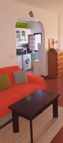 a living room with a red couch and a table at Ana Mónica Pereira in Vila Nova de Milfontes
