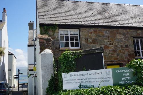a sign on the side of a brick house at Bishopsgate House Hotel in Beaumaris