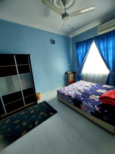 a bedroom with a bed with blue walls and a window at ASTANA INN HOMESTAY Balik Pulau in Balik Pulau