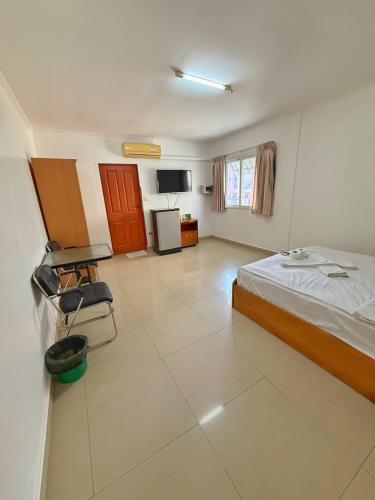 a large room with a bed and a kitchen at Malee Guesthouse & Restaurant in Pattaya
