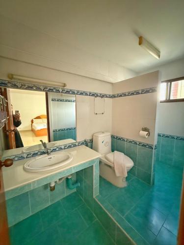 a bathroom with a sink and a toilet and a mirror at Malee Guesthouse & Restaurant in Pattaya