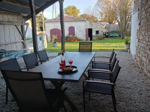 une table et des chaises avec une assiette de nourriture dans l'établissement La Demeure D'Ezilda, à Fléac-sur-Seugne