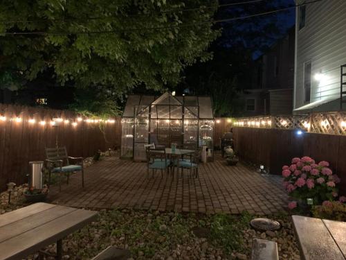 a patio with a table and lights on a fence at Magnolia Stay near New York City in Jersey City